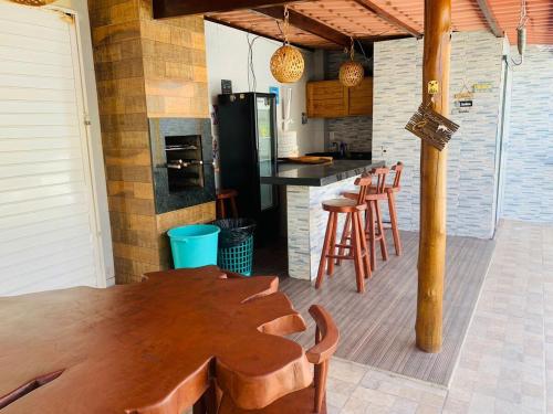 a kitchen with a wooden table and some chairs at Casa com piscina in Marechal Deodoro