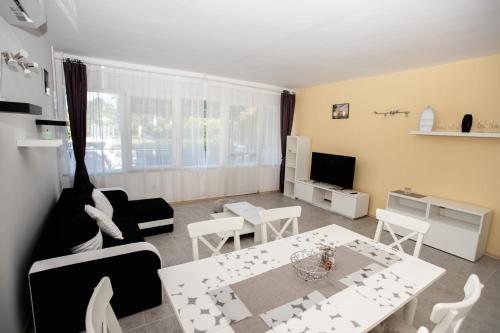 a living room with a white table and chairs at Harmónia apartman in Zánka