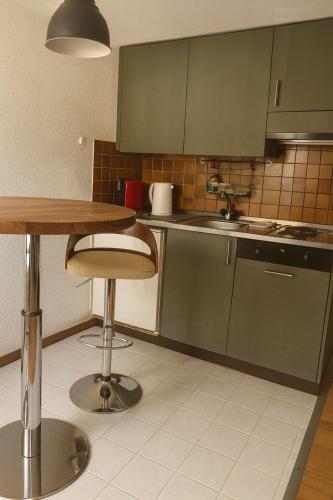 a kitchen with green cabinets and a table and a sink at Cooles Apartment an der Kathedrale in Fribourg