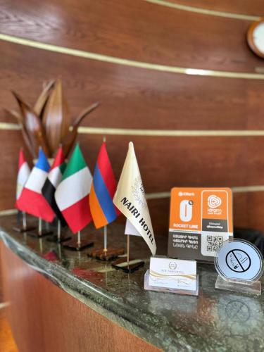 a shelf with some flags on a table at New Nairi Hotel Yerevan in Yerevan