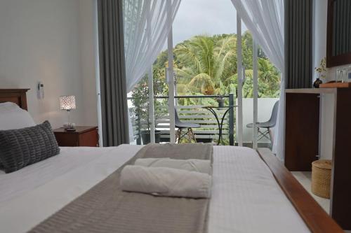 a bedroom with a large bed and a large window at K's Cove in Kandy