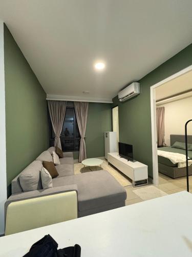 a living room with a couch and a bed and a mirror at Eclipse Residence in Cyberjaya