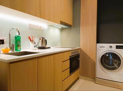 a kitchen with a sink and a washing machine at The Luxe & Colony Infinitum KLCC by CoupleStay in Kuala Lumpur