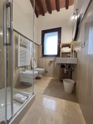 a bathroom with two toilets and a sink and a shower at La Noce di Creta in Poggio Moiano