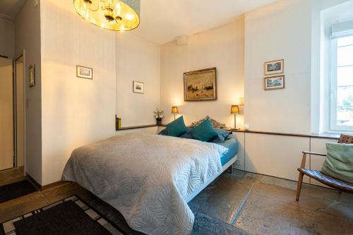 a bedroom with a bed and a window and a chandelier at Maison DuBois in Le Locle