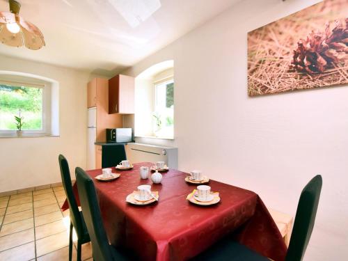 comedor con mesa roja y sillas en Spacious Holiday Home in Saint Vith with Terrace, en Schoenberg