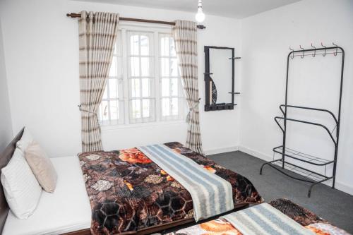 a bedroom with two beds and a window at Snowdon in Nuwara Eliya