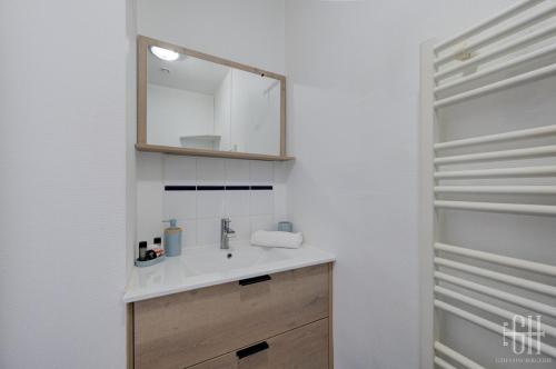 un baño con lavabo y espejo en Le Mirabeau - Gare à 100m - Wifi - Bureau - 2 V, en Saint-Pierre-des-Corps