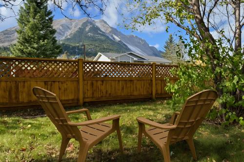 zwei Stühle in einem Garten mit einem Zaun und Bergen in der Unterkunft Hillcrest Hideaway: Spacious Mountain View Oasis in Hillcrest Mines