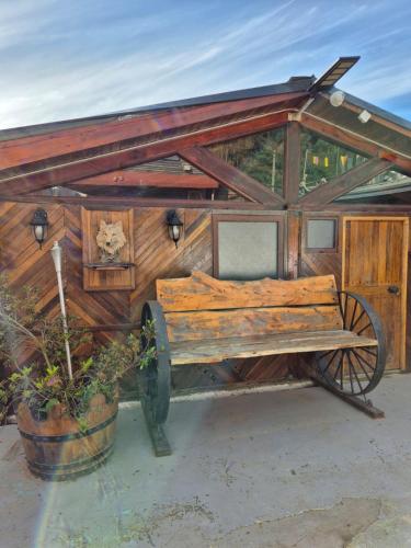 a wooden building with a bench in front of it at Cabañas el Torreón in Pelluhue