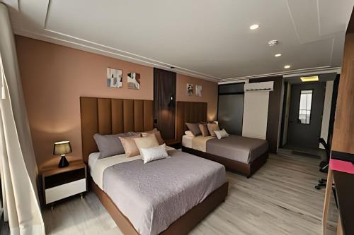 a bedroom with two beds and a table and a lamp at Epic Suite 209 Deluxe Aeropuerto in Cuba