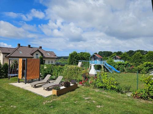 a backyard with a playground and a slide at Domek Aneczka Dębina in Dębina-Ustka