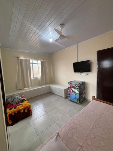 a bedroom with a bed and a flat screen tv at Pousada Fênix,com piscina -250 METROS DA PRAIA in Pontal do Paraná