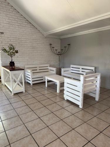 una habitación con tres bancos blancos y una mesa en Atterbury Value Bed and Breakfast, en Pretoria