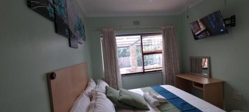 a bedroom with a bed and a window at Ojong's Guesthouse Ridgeworth - Bellville in Tyger Valley