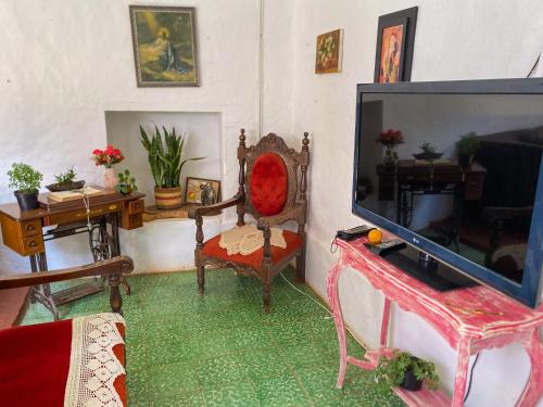 a living room with a flat screen tv and a chair at CASA MAGIA by Magally Velasco in Curití