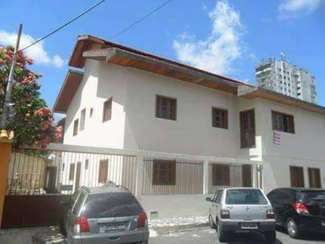 a white house with cars parked in front of it at Suíte Nazaré in Belém