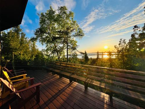 a group of benches on a deck at sunset at Silver Birch Waterfront Cottage in Tobermory