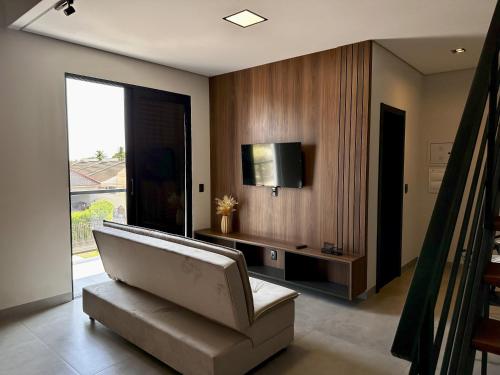 a living room with a couch and a tv at Lofts completos em Sinop MT in Sinop