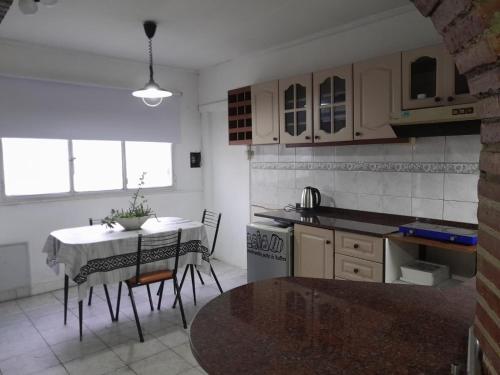 een keuken met een tafel en een keuken met een tafel en stoelen bij Monoambiente in La Porteña
