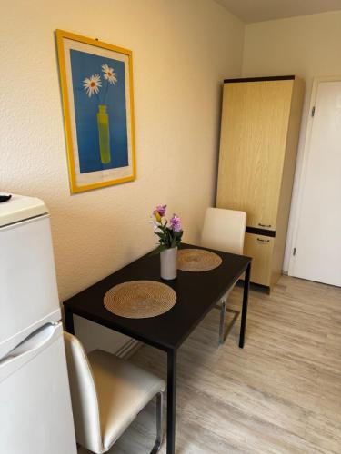 a dining room with a table with flowers on it at Kaiser-Rooms Stralsunder Ring 18 in Wolfsburg