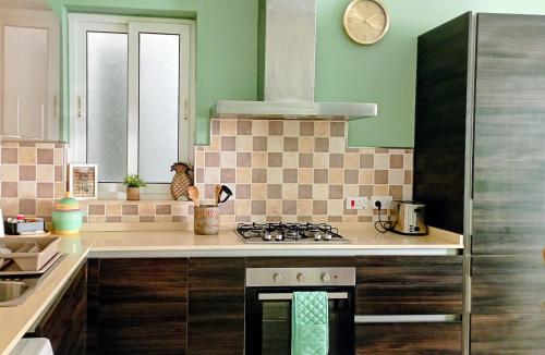 a kitchen with a stove and a clock on the wall at Home from home at the Seacrest in St. Paul's Bay