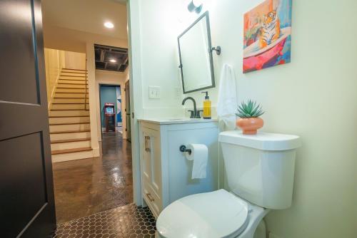 y baño con aseo, lavabo y espejo. en Historic Kirkwood Location with Arcade & Game room, en Atlanta