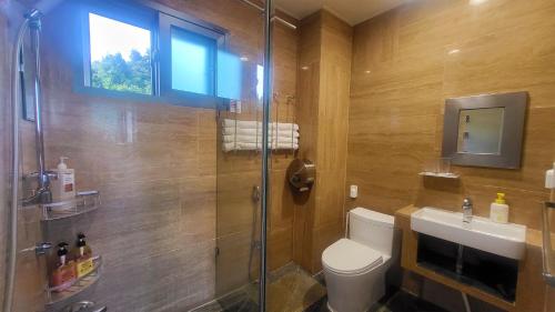 a bathroom with a shower and a toilet and a sink at OROJEJU in Seogwipo