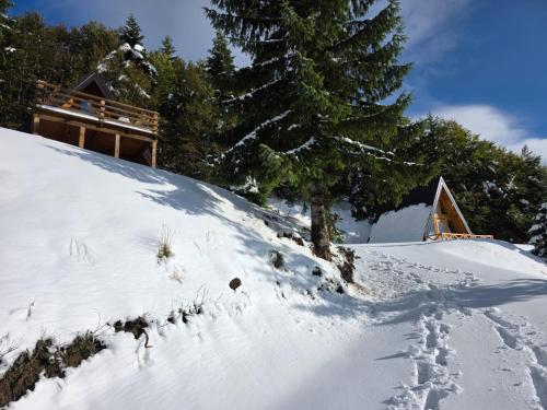 a snow covered hill with a house in the background at Komovi Luxury House in Andrijevica