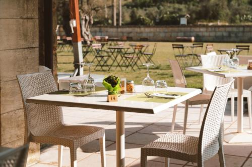 a white table with chairs and wine glasses on it at Masseria Stali, The Originals Relais in Caprarica di Lecce