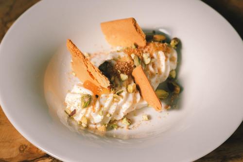 a white plate of food with carrots and other foods at Masseria Stali, The Originals Relais in Caprarica di Lecce