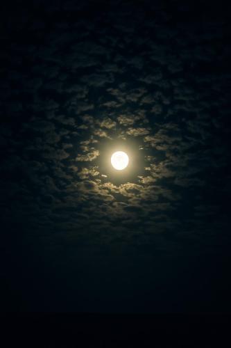 a moon in the sky with clouds at night at sabrina camp in Siwa