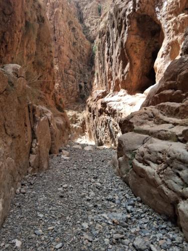 a canyon with rocks and a dirt road at Dar Essalama Dades in Akhendachou nʼAït Ouffi