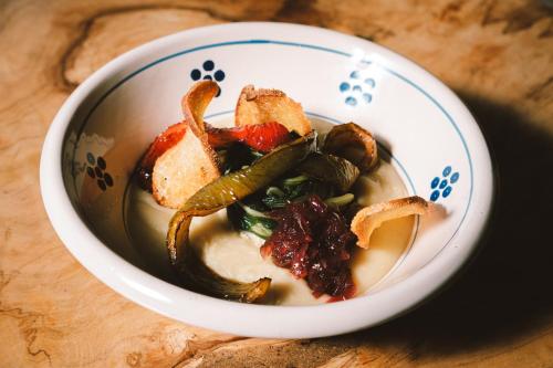 a bowl of soup with vegetables and bread on a table at Masseria Stali, The Originals Relais in Caprarica di Lecce