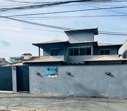a house with a wall with a sign on it at Casa de praia SANTINHO in Búzios