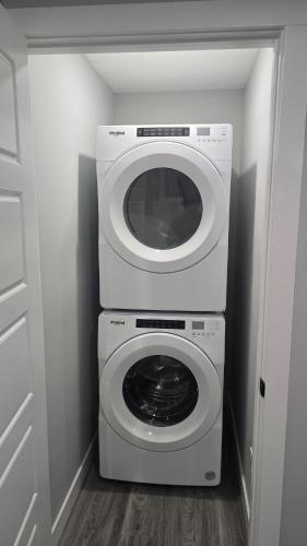 a washing machine and a dryer in a room at Royaldee Cozy Home in Calgary