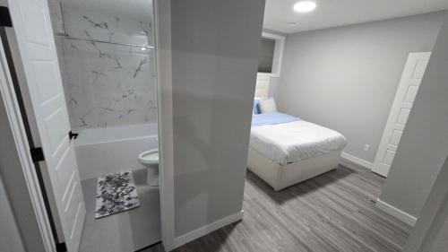 a small bathroom with a bed and a toilet at Royaldee Cozy Home 2beds & 2baths in Calgary