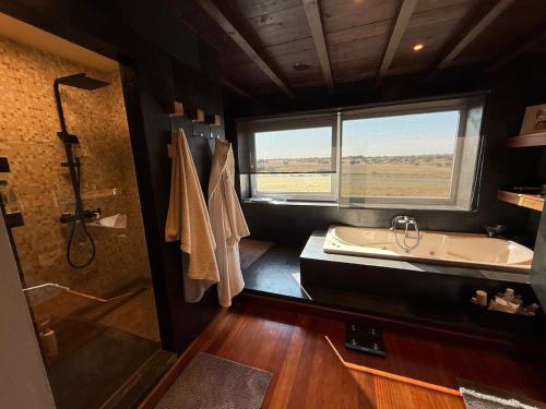 ein Badezimmer mit Badewanne, Waschbecken und Dusche in der Unterkunft Casa da Retorta in Casa Branca