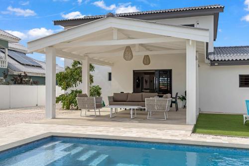 a pavilion with a pool in front of a house at 3 bedroom cozy villa close to Jan Thiel Beach in Jan Thiel