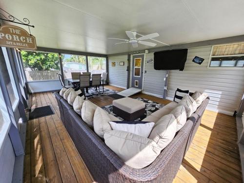a living room with a large couch and a flat screen tv at Fisherman's Hideaway! Home on canal in Okeechobee! in Okeechobee