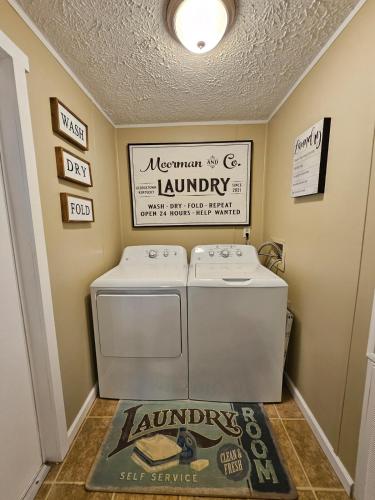 a laundry room with a washer and a sign on the wall at Fisherman's Hideaway! Home on canal in Okeechobee! in Okeechobee