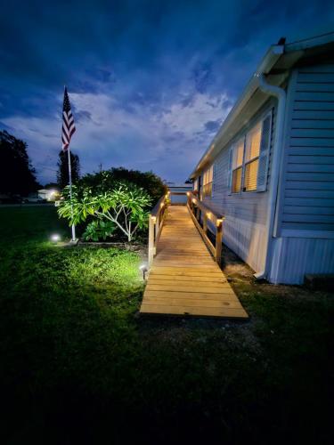 a wooden path leading to a house with an american flag at Fisherman's Hideaway! Home on canal in Okeechobee! in Okeechobee