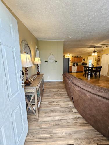 a living room with a wooden floor and a kitchen at Fisherman's Hideaway! Home on canal in Okeechobee! in Okeechobee
