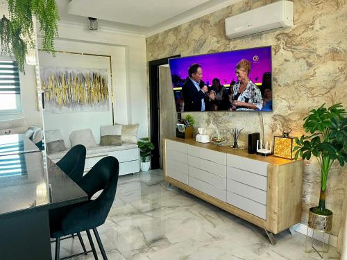 a living room with a flat screen tv on a stone wall at Violet Suite in Nyíregyháza