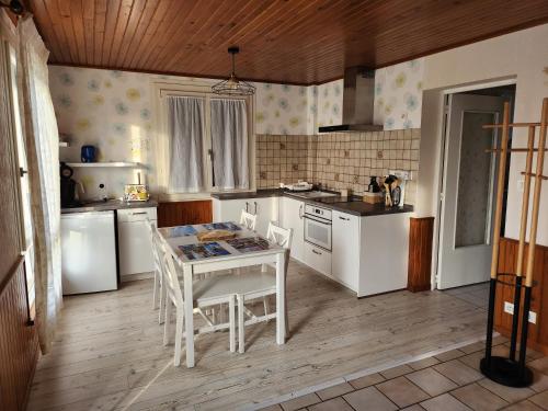 a kitchen with white appliances and a table and chairs at Chez David et Julie in La Bouverie