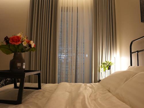 a bedroom with a bed and a vase of flowers on a table at بيت ورد in Al Madinah