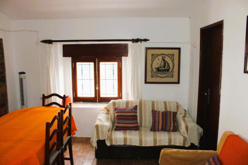 a bedroom with a bed and a chair and a window at Outra Vida in Mértola
