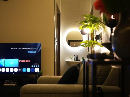 a living room with a couch and a tv at بيت ورد in Al Madinah