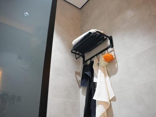 a towel rack with clothes and a bag on a wall at بيت ورد in Al Madinah