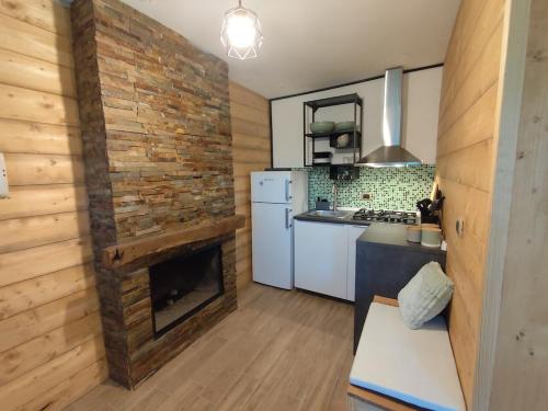 a kitchen with a brick wall and a fireplace at MarLee Mountain Home in Pizzone